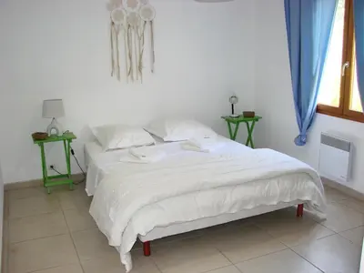 a white bed in a bedroom with two tables at beautiful 4 bedroom villa, pool, Luberon in Cadenet