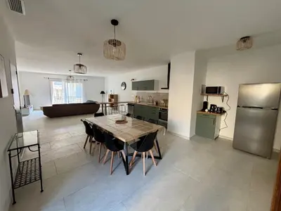 a kitchen and living room with a table and a refrigerator at Appartement 100 m carré pour 6 à 8 personnes in Saint-Cannat
