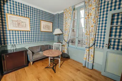a living room with a chair and a table at La Bastide de Paula in Aix-en-Provence