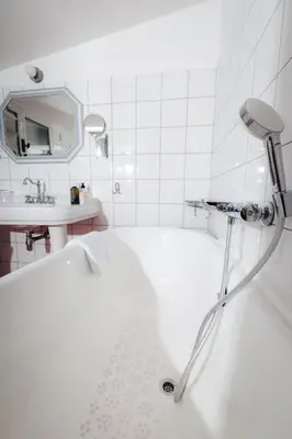 a white bathroom with a tub and a sink at La Bastide de Paula in Aix-en-Provence