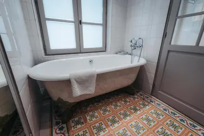 a bath tub in a bathroom with a window at La Bastide de Paula in Aix-en-Provence
