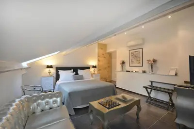 a bedroom with a bed and a living room at Le moulin vieux, mas authentique en Provence avec piscine in Entraigues-sur-la-Sorgue