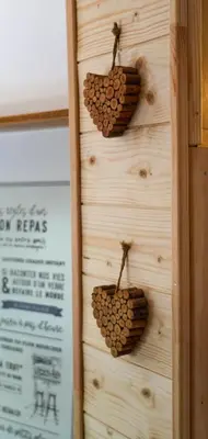 a wall of wood with two hearts on it at La cabane - Nature et Spa in Aurons