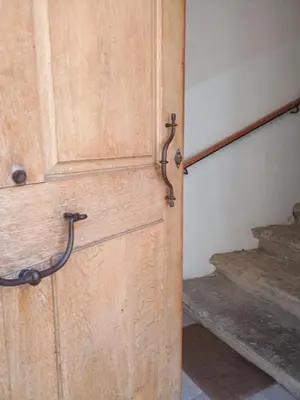 a wooden door in a room with stairs at Spacieux 74 m2 Standing Clim & Parking Privé Centre Ville in LʼIsle-sur-la-Sorgue
