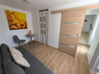 a living room with a couch and a wooden door at Maison au coeur de Banon in Banon