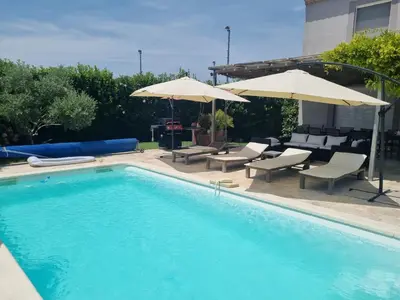 a swimming pool with chairs and umbrellas next to at Beautiful Villa Pool in Provence in Monteux