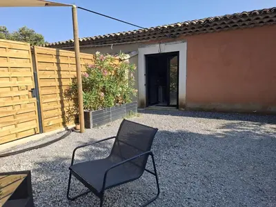 a black chair sitting in front of a fence at logement indépendant avec terrasse privative dans les Alpilles in Aureille
