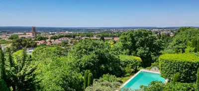 a swimming pool in a garden with trees at Villa de charme avec Piscine & Vue panoramique en plein Centre-ville d'Aix-en-Provence in Aix-en-Provence
