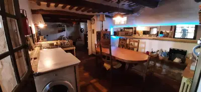 a restaurant with a table and a counter and a bar at Maison de famille traditionnelle provençale in Gordes
