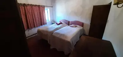 a bedroom with two beds and a window at Maison de famille traditionnelle provençale in Gordes