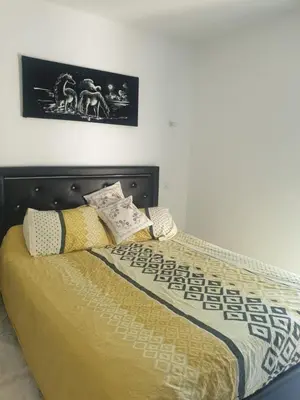 a bedroom with a bed with a yellow comforter and pillows at Villa in Carpentras