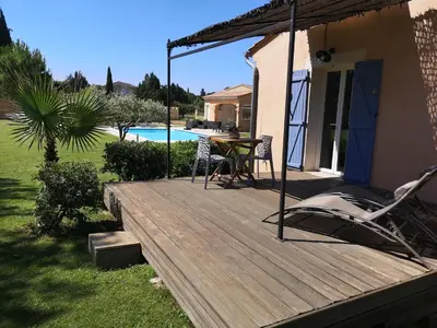 a wooden deck with a table and chairs on it at Gite confort et Calme Casa La Piboulette in Carpentras