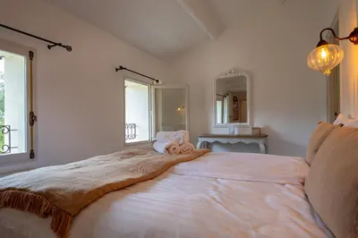 a bedroom with a large bed with a blanket on it at Gîte Terrasse in Gordes