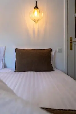 a bed with a pillow and a light on the wall at Gîte Terrasse in Gordes