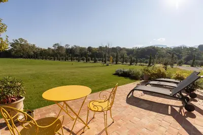 a patio with a table and chairs and a bench at Terres Élaïs in Robion en Luberon