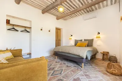 a bedroom with a bed and a couch in a room at Terres Élaïs in Robion en Luberon