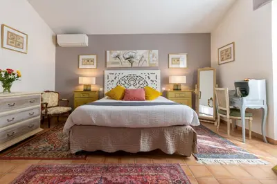 a bedroom with a bed and a dresser and a television at La Bastide des Amouriers in Caumont-sur-Durance