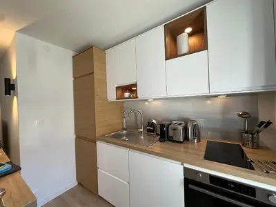 a kitchen with white cabinets and a sink at Le Nid des Cardeurs studio cosy centre historique in Aix-en-Provence