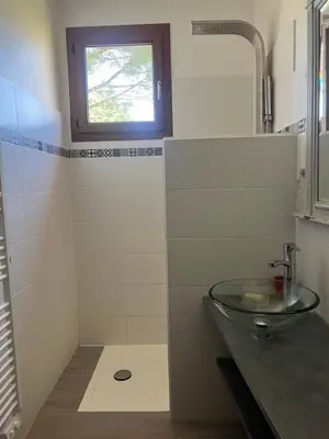 a bathroom with a glass sink and a window at Maison familiale Luberon in Lauris