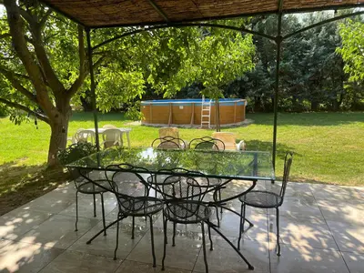 a glass table and chairs under a pavilion at Maison familiale Luberon in Lauris