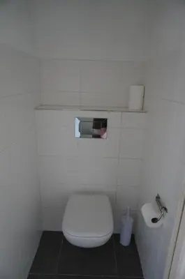 a white bathroom with a toilet and a roll of toilet paper at Appart Suite Privilege XL avec Parking in Salon-de-Provence
