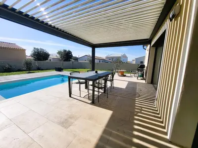 a patio with a table and chairs next to a pool at Friendly and warm villa with pool in Pernes-les-Fontaines