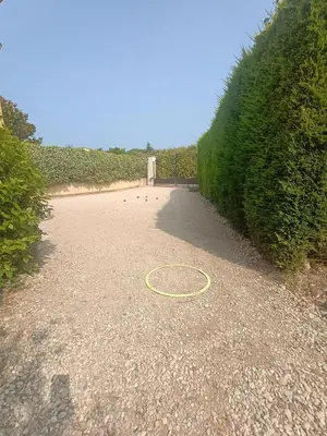 a hula hoop on a gravel road next to a hedge at Maison villa avec piscine et spa, 8 à 10 personnes in LʼIsle-sur-la-Sorgue