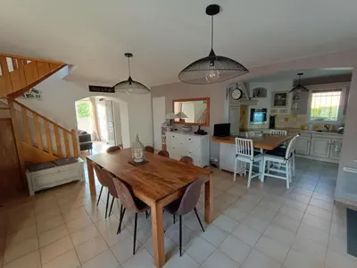 a kitchen and dining room with a wooden table and chairs at Maison villa avec piscine et spa, 8 à 10 personnes in LʼIsle-sur-la-Sorgue