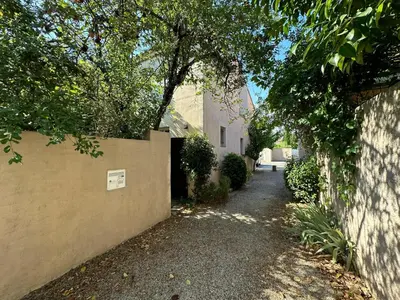 an alley way next to a building with a tree at La Maison du Petit Hérisson de 170 m2 avec jardin parking accueil de 6 personnes barbecue in Aix-en-Provence
