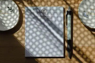a pen sitting next to a piece of paper on a table at Villa Augustine - Maison classée 5 étoiles avec piscine à Aix en Provence in Aix-en-Provence