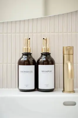 two bottles of shampoos sitting on a shelf at Villa Augustine - Maison classée 5 étoiles avec piscine à Aix en Provence in Aix-en-Provence