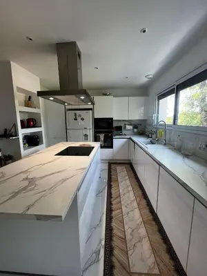 a kitchen with white cabinets and a counter top at Belle villa à Carpentras in Carpentras