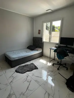 a bedroom with a bed and a desk and a computer at Belle villa à Carpentras in Carpentras