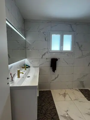 a white bathroom with a sink and a window at Belle villa à Carpentras in Carpentras