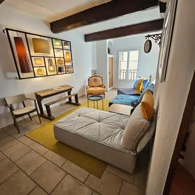 a living room with a couch and a table at Maison au Cœur de Isle-sur-la-Sorgue in LʼIsle-sur-la-Sorgue