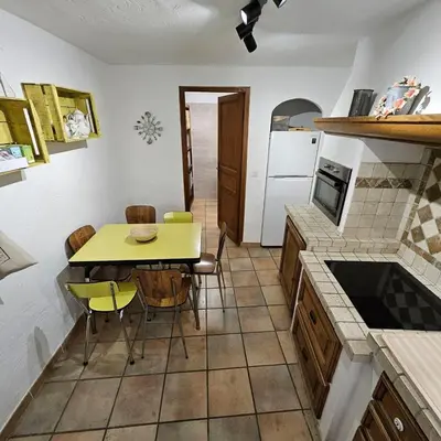 a kitchen with a table and a yellow table and chairs at Maison au Cœur de Isle-sur-la-Sorgue in LʼIsle-sur-la-Sorgue