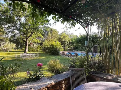 a garden with a park with a pool and trees at maison de charme en Luberon in Gignac