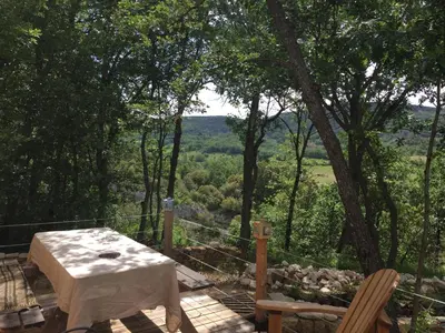 a table and chairs on a deck with a view at maison de charme en Luberon in Gignac