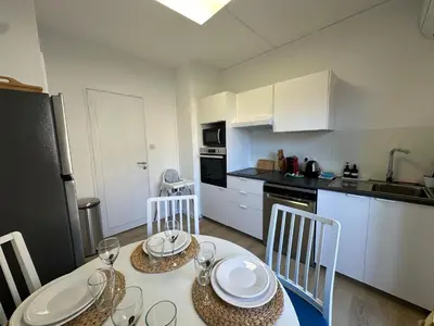 a kitchen with a table and chairs in a room at L'étape Aixoise - appartement climatisé terrasse centre ville Rotonde cours Mirabeau allées provençales in Aix-en-Provence