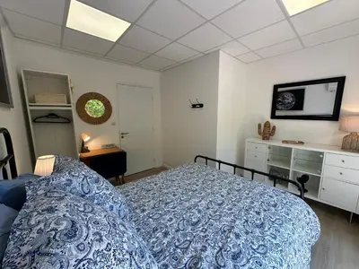 a bedroom with a blue bed and a dresser at L'étape Aixoise - appartement climatisé terrasse centre ville Rotonde cours Mirabeau allées provençales in Aix-en-Provence