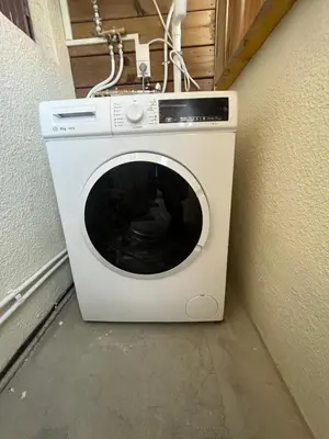 a white washing machine sitting next to a wall at L'étape Aixoise - appartement climatisé terrasse centre ville Rotonde cours Mirabeau allées provençales in Aix-en-Provence