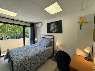 a bedroom with a bed and a banana on the wall at L'étape Aixoise - appartement climatisé terrasse centre ville Rotonde cours Mirabeau allées provençales in Aix-en-Provence