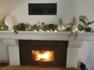 a fireplace with christmas decorations on top of it at Trés jolie bastidon de village in Puyvert