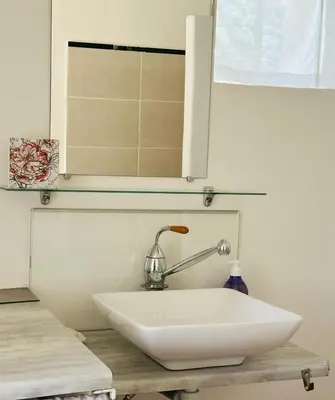 a white sink in a bathroom with a mirror at Le Bastidon in Caseneuve
