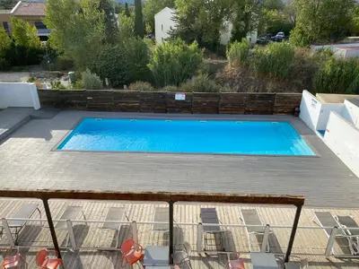 a large blue swimming pool on a wooden deck at Ma place au sud 216 in Éguilles