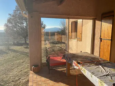 a bed on a porch with a view of a window at Villa de l'Argau in Revest-du-Bion