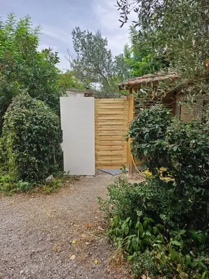 a white refrigerator in front of a wooden fence at Escapade en caravane près d'aix en provence in Meyreuil