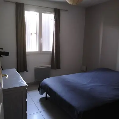 a bedroom with a blue bed and a window at L infiniment zen in Caromb