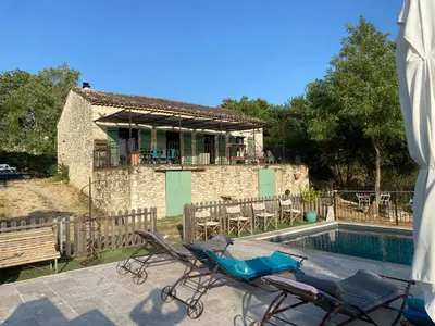 a house with a pool and two chairs and a house at Les terrasses des pourquiers in Gordes