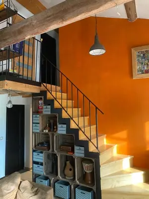 a staircase in a room with orange walls at Les terrasses des pourquiers in Gordes